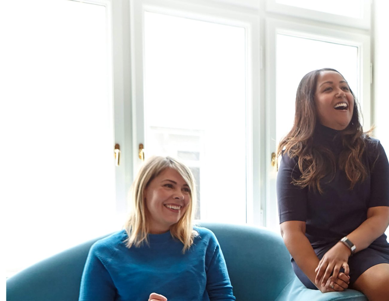 Two smiling woman in a meeting room