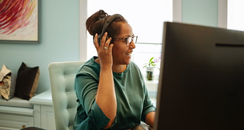 Picture of woman with headset in front of computer