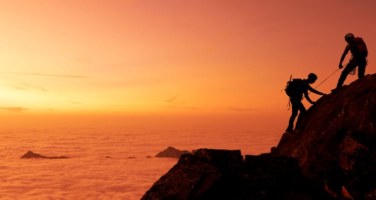 Two people climbing a high mountain