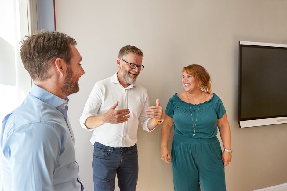 Three people having a friendly chat in the office