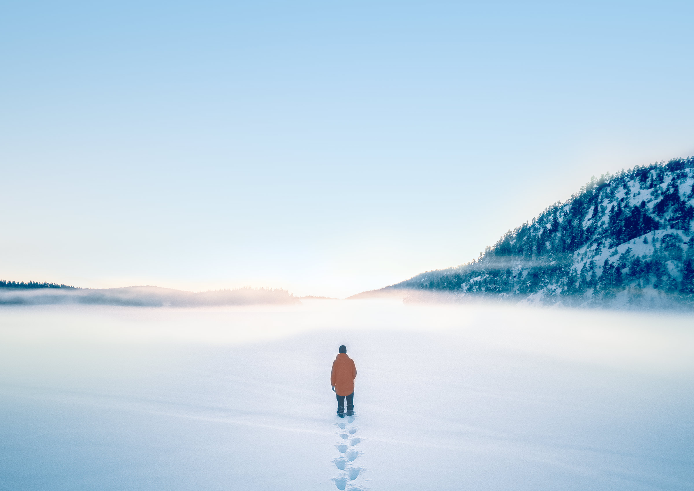 Winter scene. Man walking on a frozen lake.
