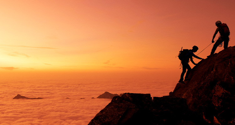 Two people climbing a high mountain