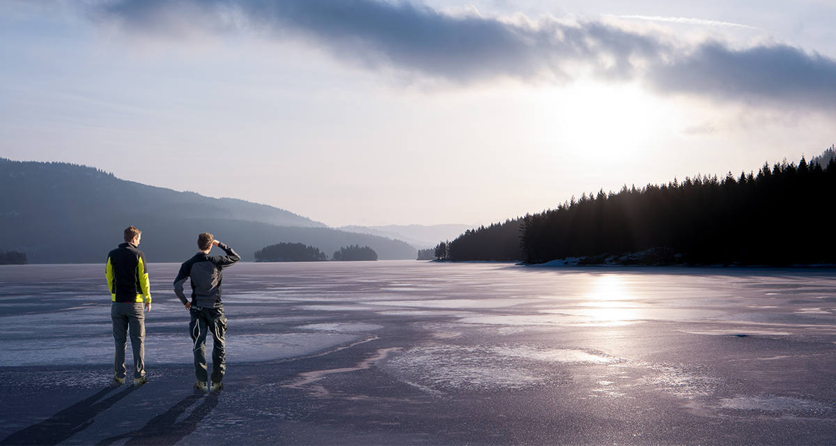 2 men overlooking a lake